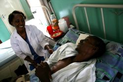 AIDS patient Geoffrey Mwila, with palliative care nurse Mercy Ngandwe by his bedside at the Mother of Mercy hospice in Chilanga, Zambia. / Credit:Jorrit Meulenbeek